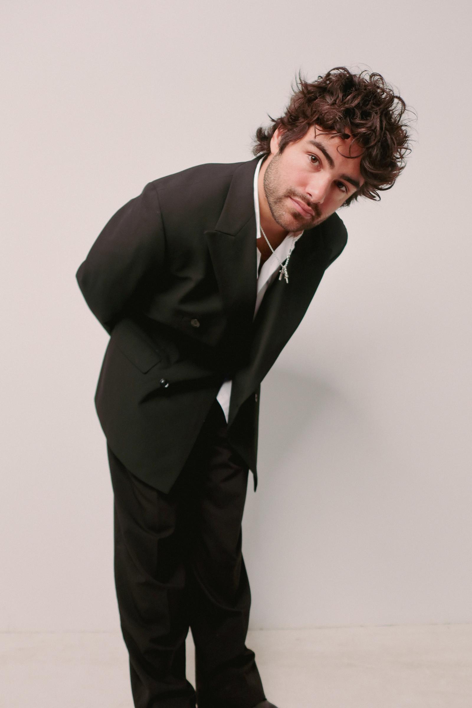 Mooglie, studio portrait in a dark leather jacket